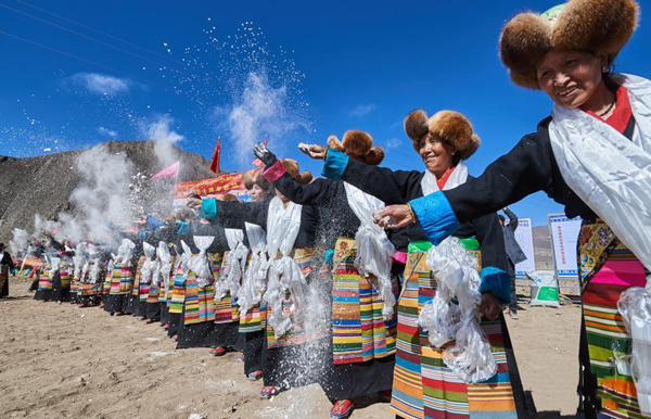 3月16日，西藏拉萨堆龙德庆区马乡马村身着节日盛装的农民们把糌粑抛向天空，祈愿风调雨顺，庄稼丰收。.jpg