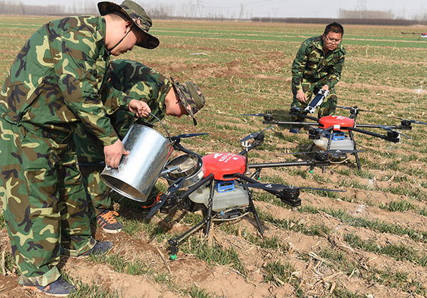 3月14日，工作人员在泊头市付村为无人机添加农药，准备对小麦进行喷药作业。.jpg